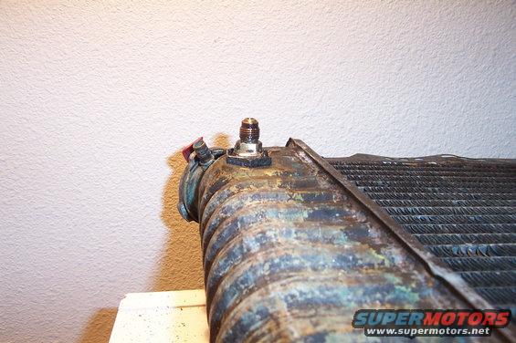 Corroded radiator with a brass fitting and red cap