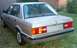 1989 BMW 3 Series - This 1989 BMW 325i sedan is shown from the rear, parked on a grassy area next to a wooden fence.