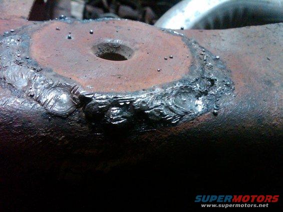 Rusty metal part with rough welds and a central hole