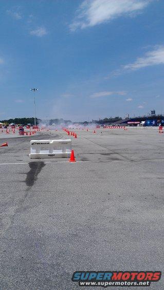Race track with smoke, cones, and grandstands