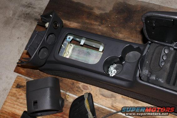 Disassembled car center console with cup holders and wiring visible