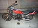 1983 Honda CB550 - Motorcycle with red fuel tank and black seat, parked indoors.