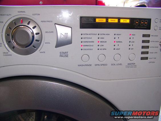 Washing machine control panel with cycle selector dial, digital display, and buttons for wash/rinse, spin speed, soil level, and beeper