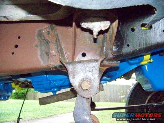 Vehicle frame with rust and blue painted components, viewed from underneath