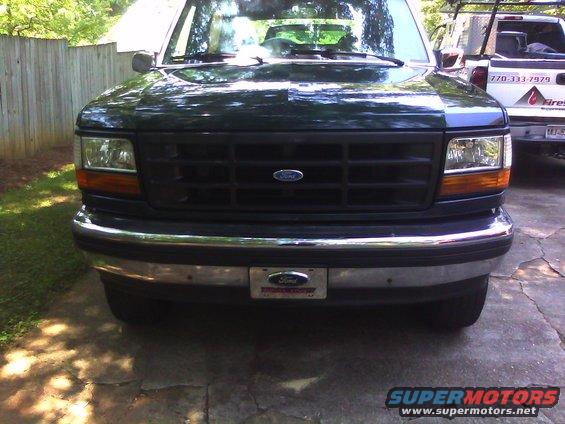 Dark green 1992 Ford Bronco front view, chrome bumper, black grille, parked on concrete