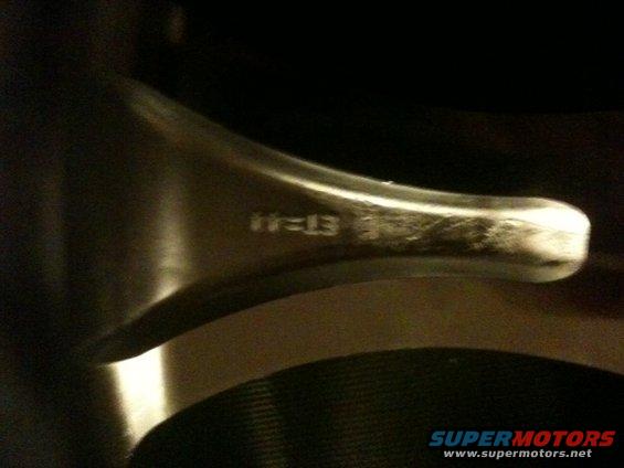 Close-up of a car wheel with markings that say "11=13"