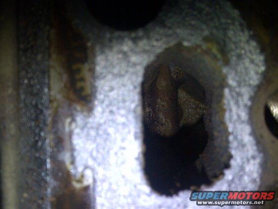 Close-up of a corroded engine cylinder head with visible rust and debris