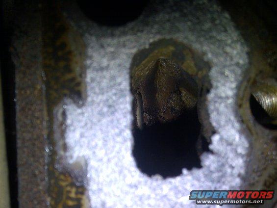 Close-up of a dirty engine part with a pointed protrusion