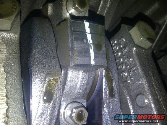 Close-up of engine connecting rod bearing with white paint mark