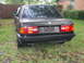 1991 BMW 3 Series - Rear view of a black 1991 BMW 325i sedan parked outdoors on grass.