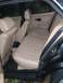 1991 BMW 3 Series - The interior of a car shows tan seats and door panels, with a black seatbelt visible.