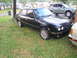 1991 BMW 3 Series - A black 1991 BMW 3 Series sedan is parked on a grassy lawn next to another vehicle.