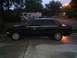 1991 BMW 3 Series - A black sedan is parked on a driveway at dusk, with a street and houses in the background.
