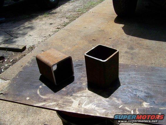 Two rusty steel square tubes on a wooden surface
