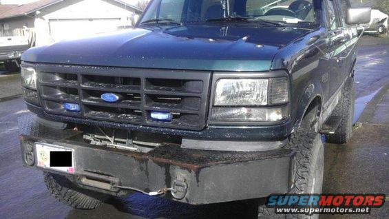 Front view of a dark green 1995 Ford Bronco with a black grille and aftermarket bumper