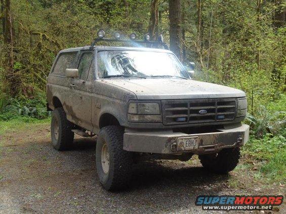 Mud-covered 1992 Ford Bronco with roof lights and aftermarket bumper