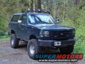 1995 Ford Bronco XLT FSB with roof rack and off-road lights parked on dirt road