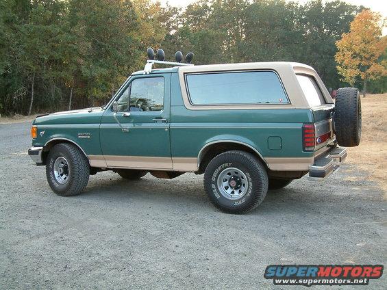1990 Ford Bronco, green with tan top, side view, spare tire mounted on rear door