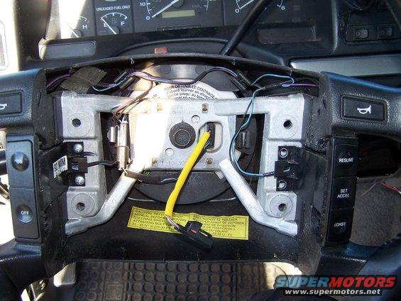 1995 Ford Bronco steering column with wiring exposed and dashboard gauges visible