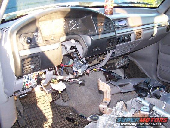 Disassembled dashboard interior with exposed wiring and parts