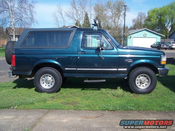 1995 Ford Bronco, dark teal, side view, lifted suspension, spare tire on rear door