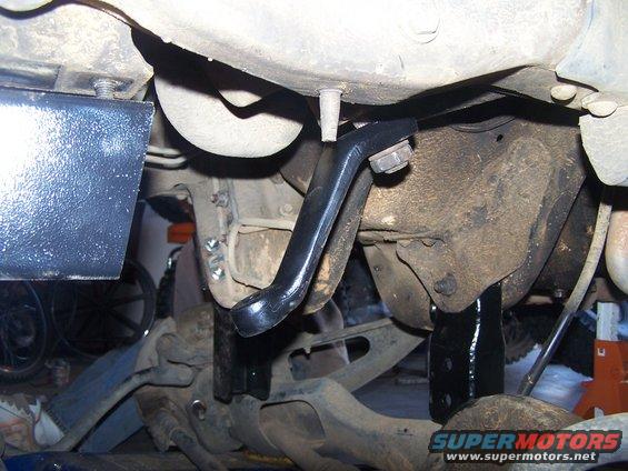 Black suspension bracket attached to rusty frame, with Supermotors.net logo