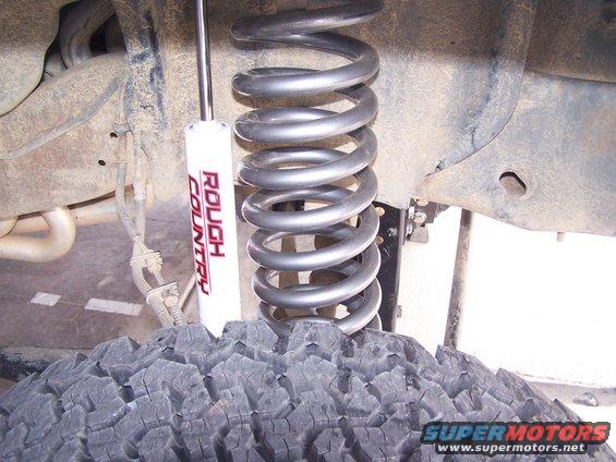 Coil spring and Rough Country shock absorber on off-road tire
