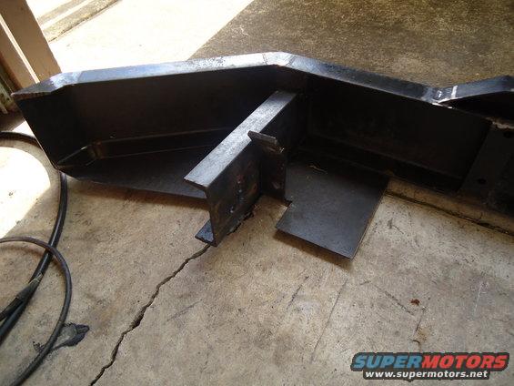 Black metal custom bumper section with internal bracing, on a concrete floor