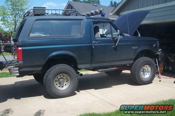 1995 Ford Bronco with lifted suspension, roof rack, and hood open
