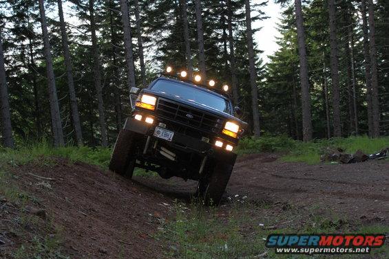 Black 1992 Ford Bronco with roof lights driving off-road
