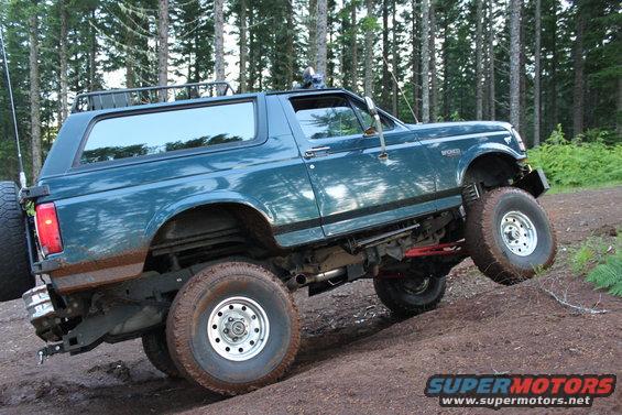 Teal 1995 Ford Bronco climbing a dirt hill