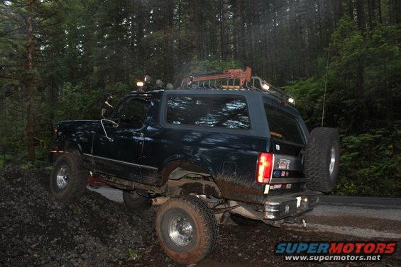 1995 Ford Bronco rear 3/4 view, dark blue, off-road tires, roof rack