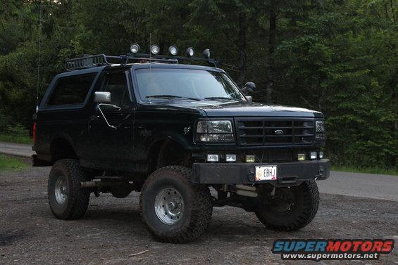 1995 Ford Bronco with roof rack and off-road tires parked on dirt road