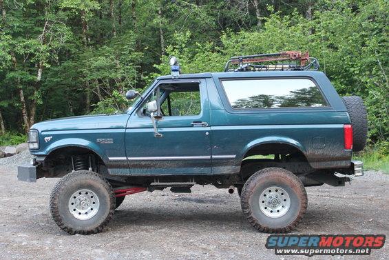 Teal 1995 Ford Bronco with roof rack and off-road tires parked outdoors