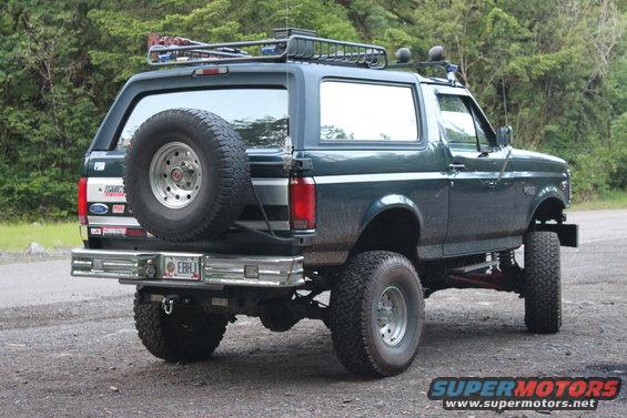 Dark green 1995 Ford Bronco with a roof rack and spare tire on the back
