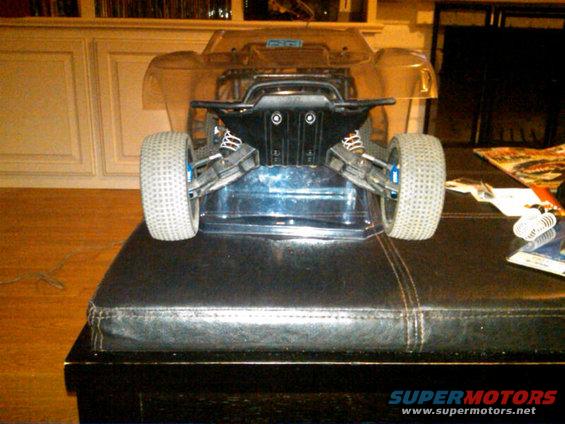 Remote control car chassis with large tires and suspension, viewed from rear