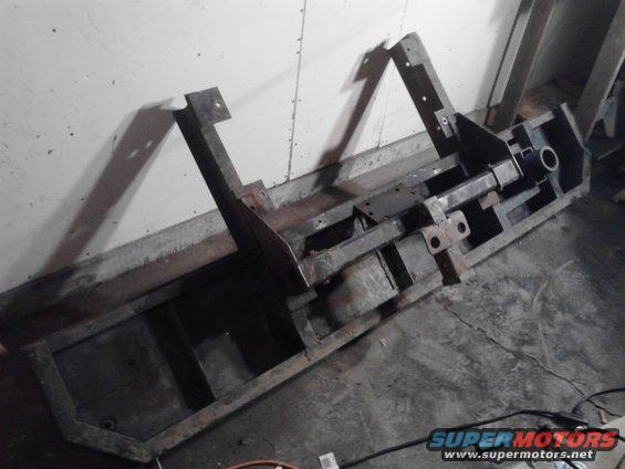 Custom metal frame, possibly for a bumper or trailer hitch, lying on a concrete floor