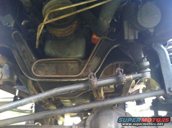 Underside view of a vehicle's steering and suspension components, showing linkages and hoses
