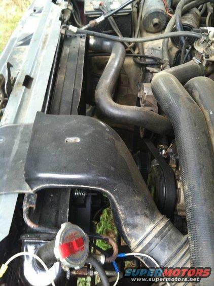 Engine bay of a 1991 Ford Bronco, showing radiator, hoses, and belts