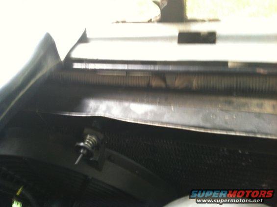 Close-up of radiator and hood latch mechanism with spring