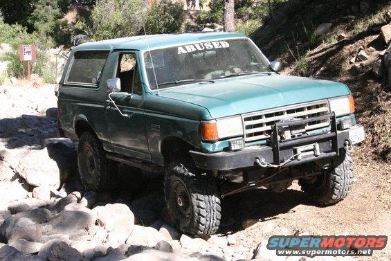 Green 1991 Ford Bronco with winch on rocky terrain