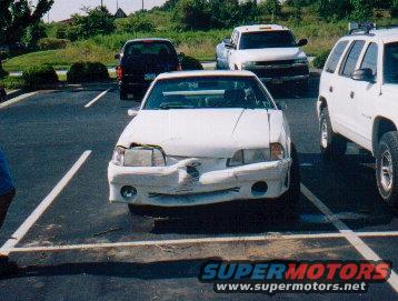 White sedan, front view, damaged bumper and headlights