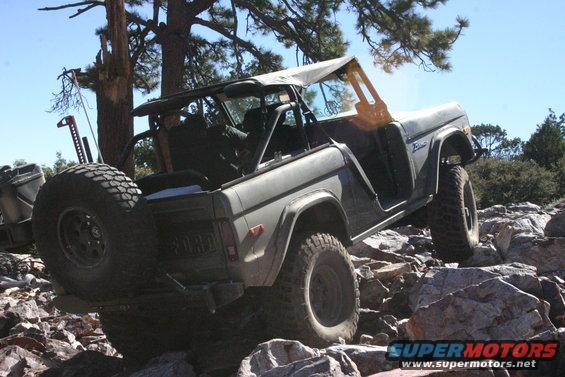 1978 Ford Bronco navigating a rocky trail, soft top removed