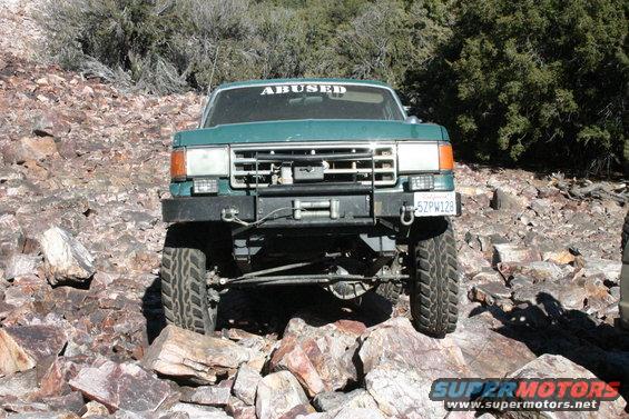 Green 1991 Ford Bronco front view with winch and "ABUSED" sticker