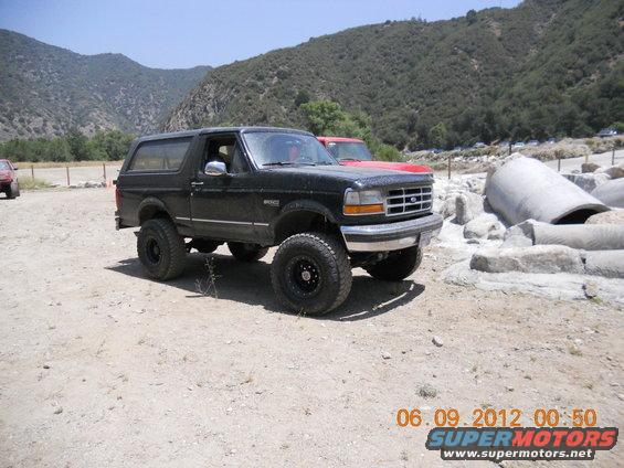 Black Ford Bronco SUV with lifted suspension and off-road tires parked on a dirt lot