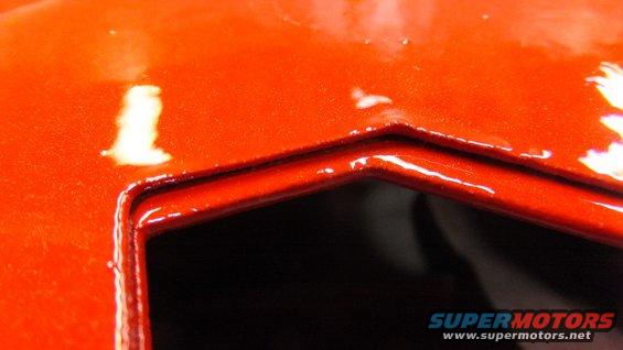 Orange painted metal panel with a recessed area and glossy finish