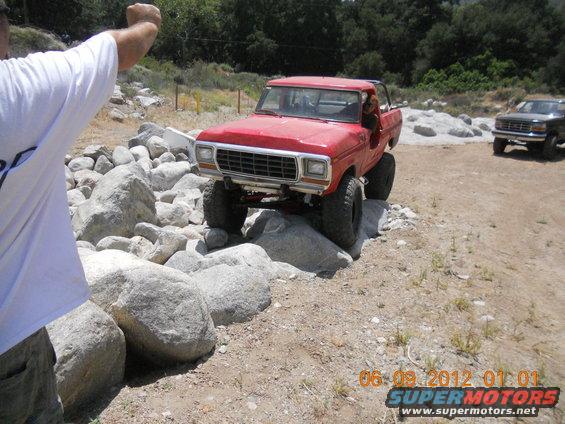 Red 1979 Ford F-150 pickup truck navigating rocky terrain