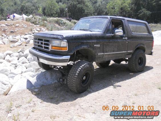 Black Ford Bronco on rocks, lifted with big tires