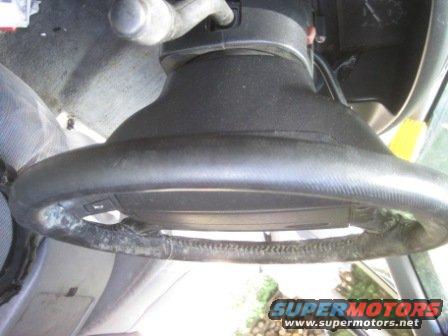Worn steering wheel with visible damage to the leather wrap