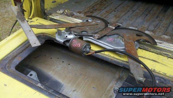 Window regulator mechanism with motor and wiring on yellow surface
